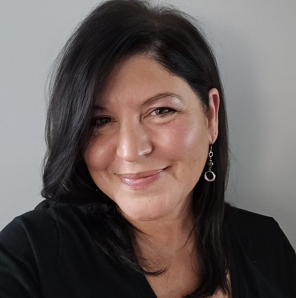 Smiling woman with dark hair, dangling earrings